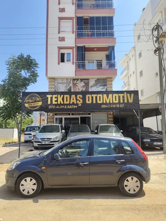 Tekdaş Otomotiv tabelası önündeki Ford hatchback