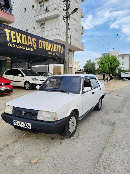 Galerinin önünde beyaz Tofaş sedan